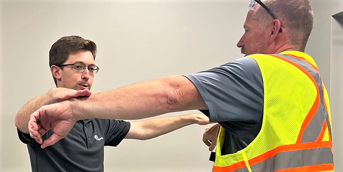 Athletic trainer helping an employee